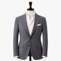 Checkered blazer on a mannequin with a white shirt and pocket square against a white background